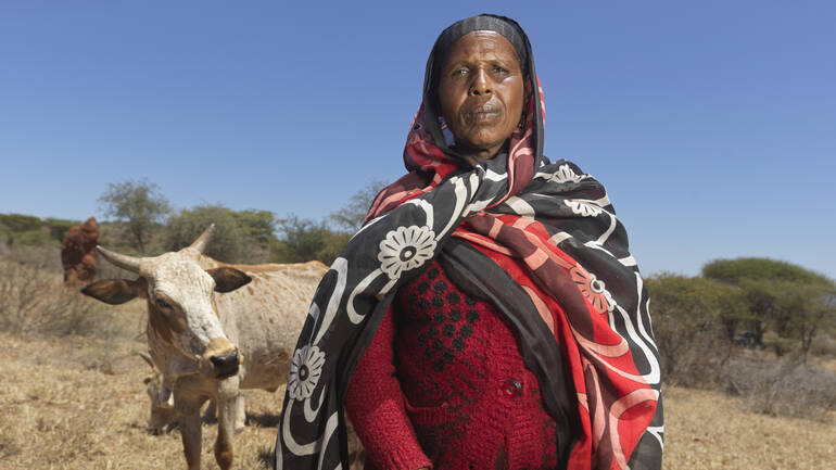Äthiopien: Eine Frau steht neben ihrem durstigen Rind. Die Dürre lässt Wasserquellen versiegen und entzieht den Gemeinschaften die Lebensgrundlagen.