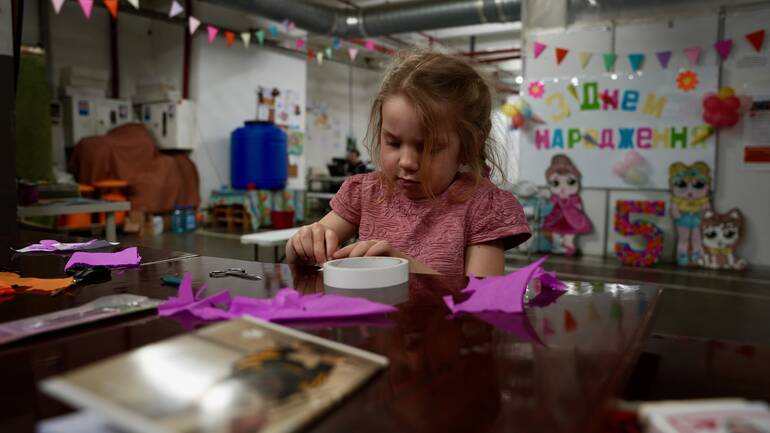 Die fünfjährige Kira aus der Ukraine bastelt konzentriert an einem Geschenk für ihre Mama.