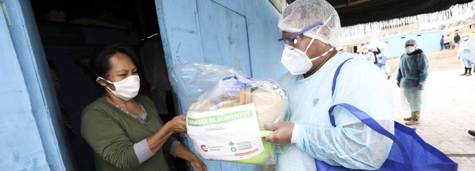 Mitarbeiter von Aktion gegen den Hunger übergibt Lebensmittelpaket.