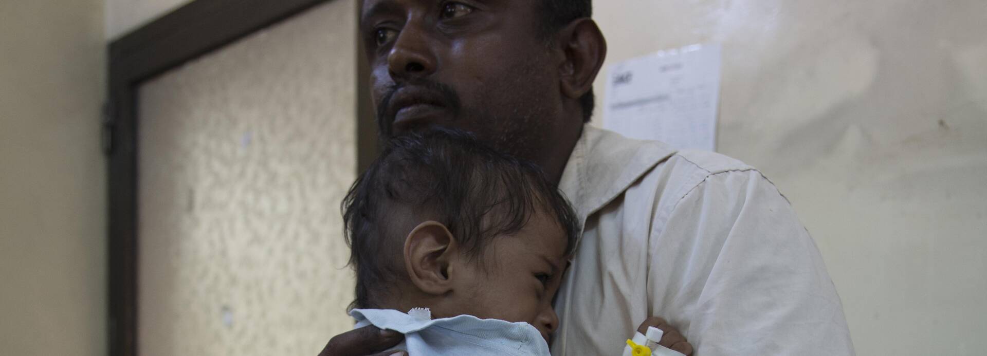 Junge im Jemen schmiegt sich an seinen Vater an