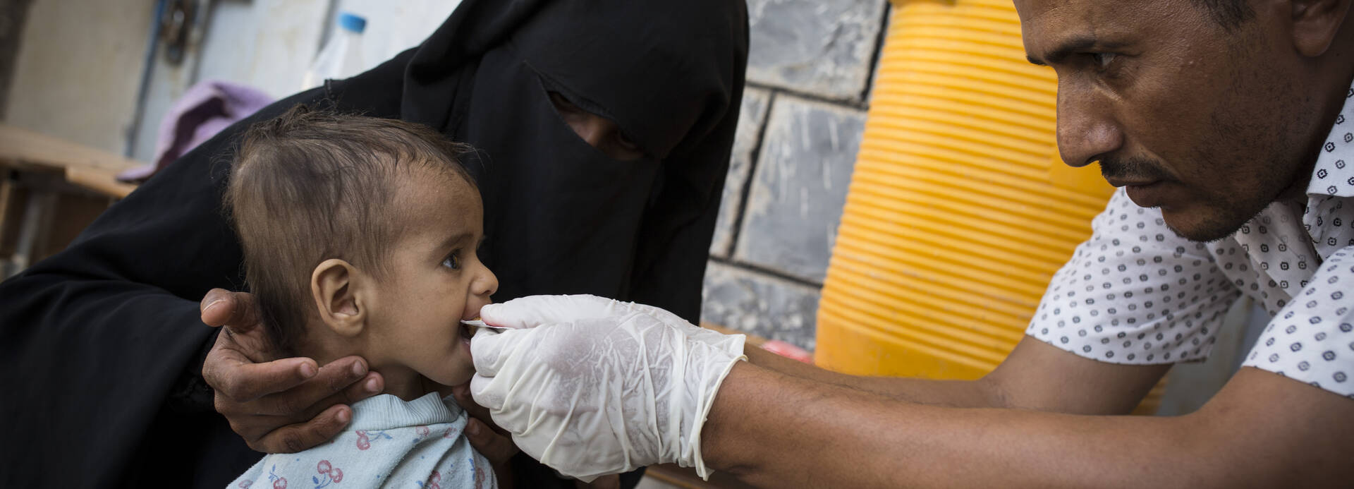Mitarbeiter von Aktion gegen den Hunger versorgt mangelernährtes Kind im Jemen