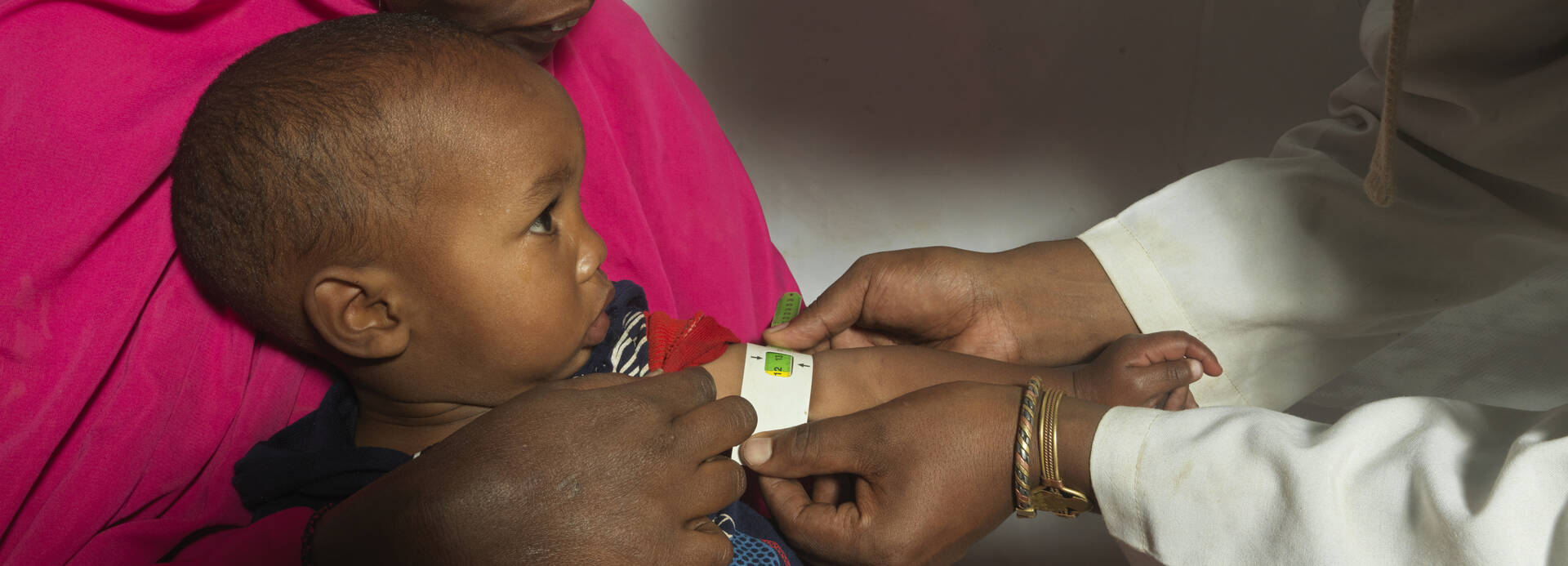 Kind wird von Aktion gegen den Hunger mit MUAC Band auf Mangelernährung untersucht