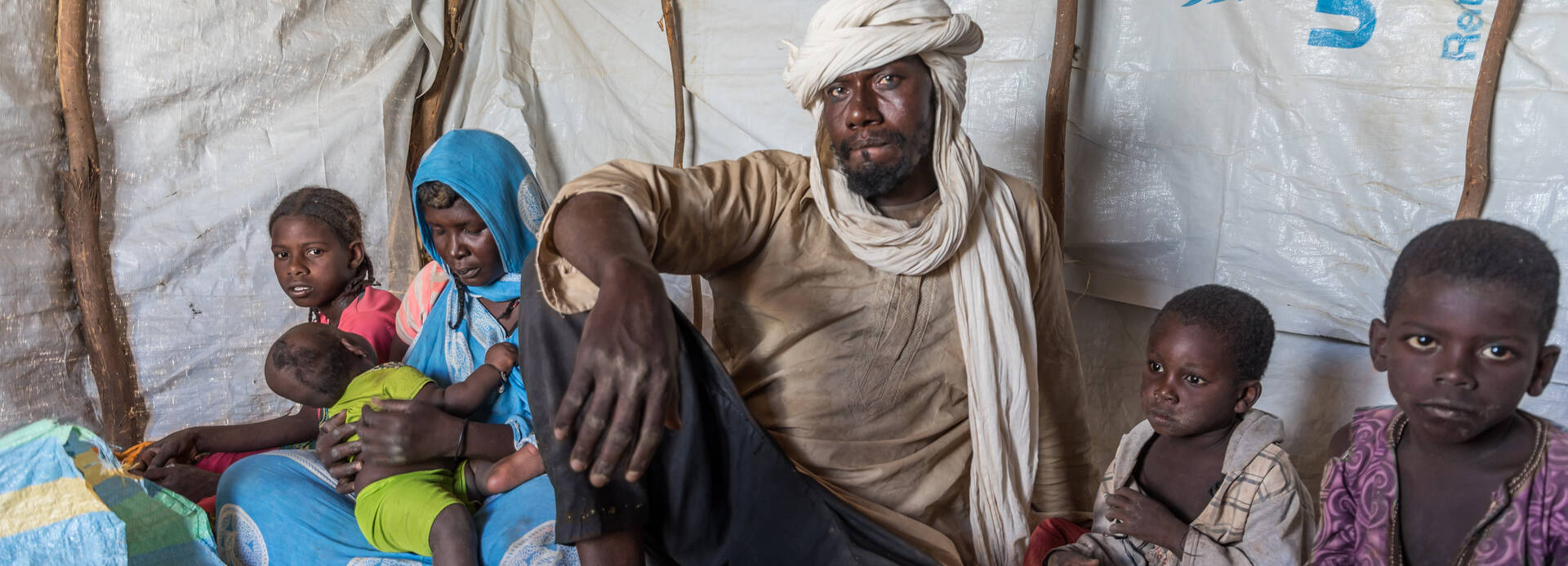 Irza und seine Familie sitzen in ihrer Zeltunterkunft im Niger.