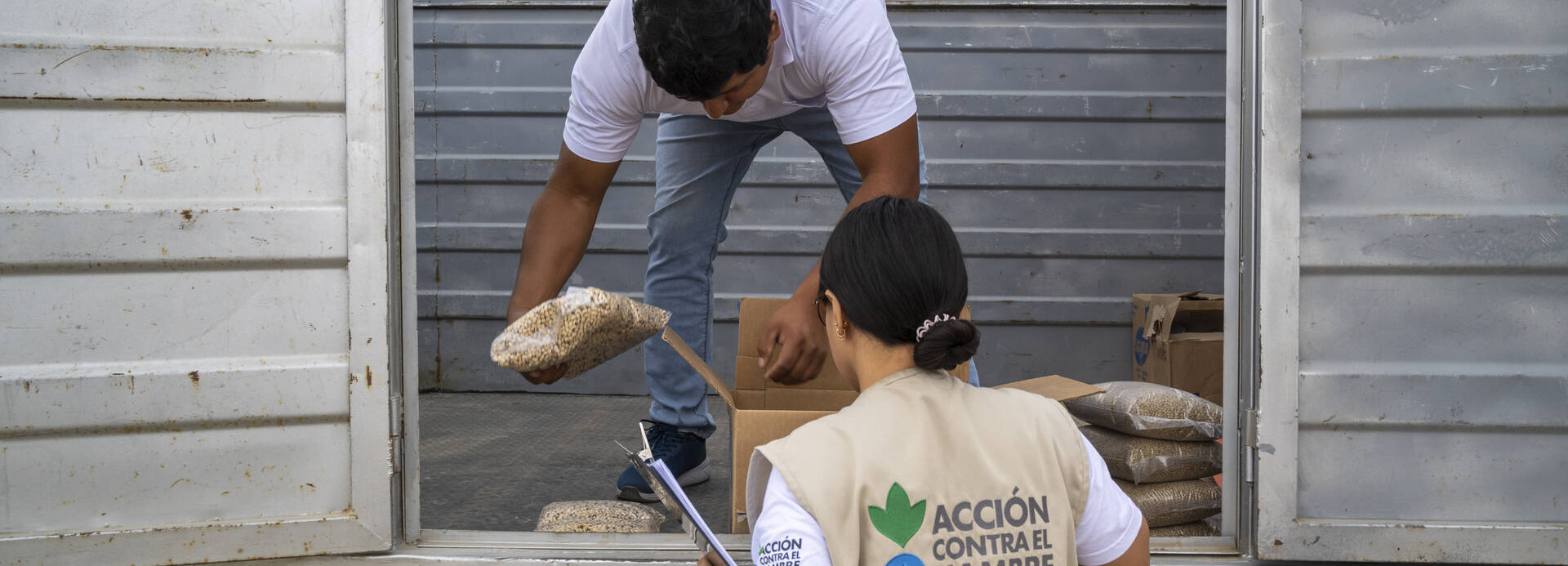 Zwei unserer Mitarbeitenden in Peru entladen einen Lastwagen mit Hilfsgütern