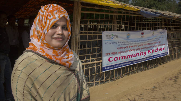 Mitarbeiterin von Aktion gegen den Hunger in Bangladesch vor einer Gemeinschaftsküche