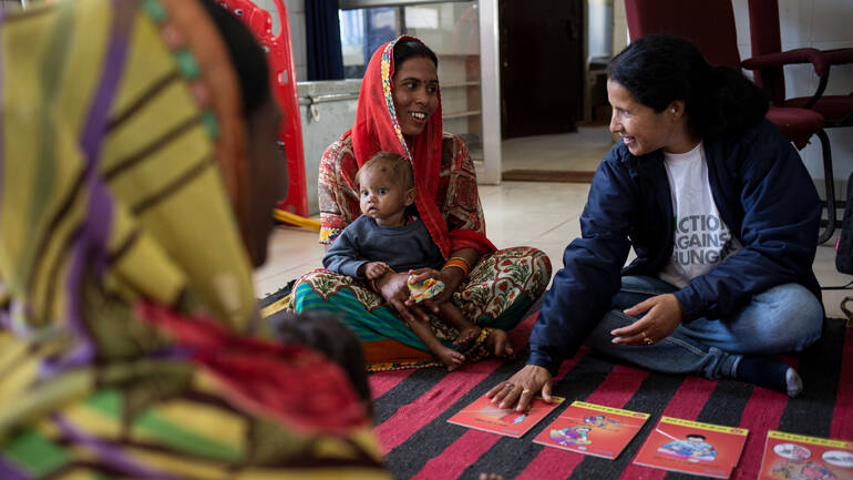 Sunita und Bhumika lachen zusammen mit einer Mitarbeiterin von Aktion gegen den Hunger während einer Schulung.
