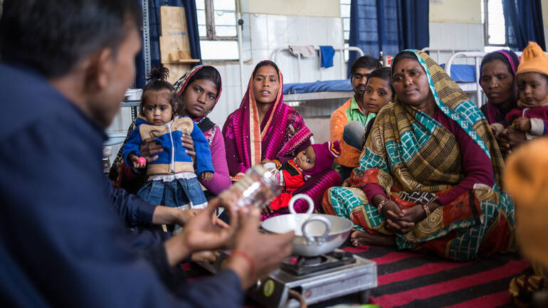 Sunita und Bhumika bei einer Kochschulung zusammen mit anderen Müttern und ihren Kindern in der Klinik.