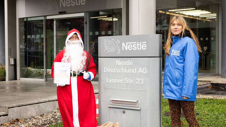 Der Nikolaus mit Rute und Unterschriften und eine Campaignerin am Briefkasten der Nestlé-Konzernzentrale in Frankfurt am Main.