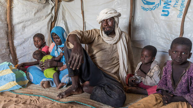 Irza und seine Familie sitzen in ihrer Zeltunterkunft im Niger.