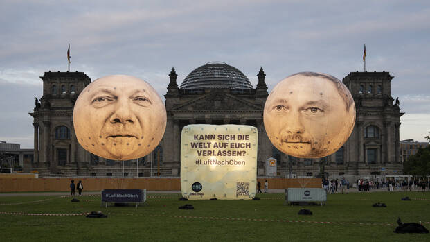 Ballons mit den Gesichtern von Olaf Scholz und Christian Lindner vor dem Reichstagsgebäude in Berlin: Kann sich die Welt auf euch verlassen? #LuftNachOben