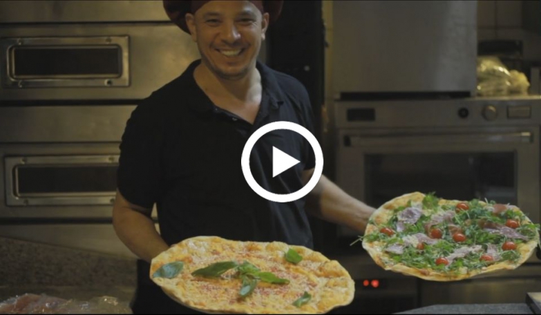 Koch, der 2 Charity-Pizzen in der Hand hält