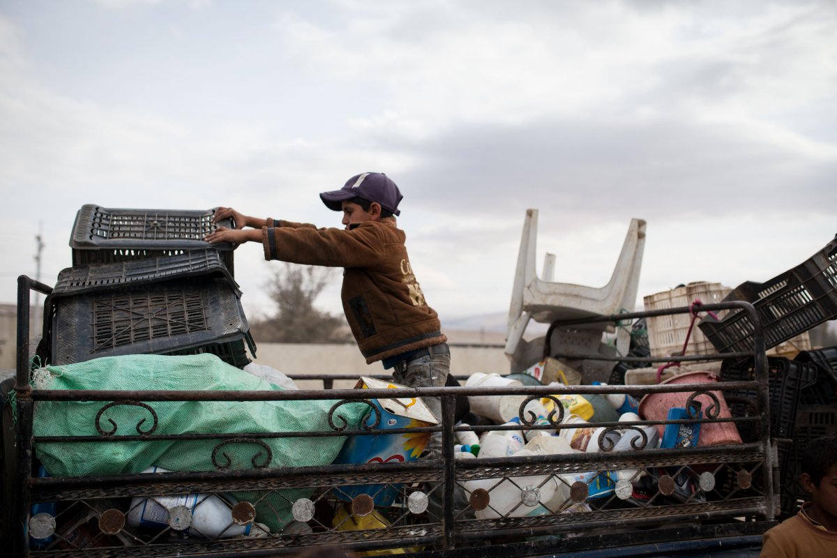 Ein Junge stapelt den Müll auf dem Pick-up. ©Aktion gegen den Hunger/Florian Seriex