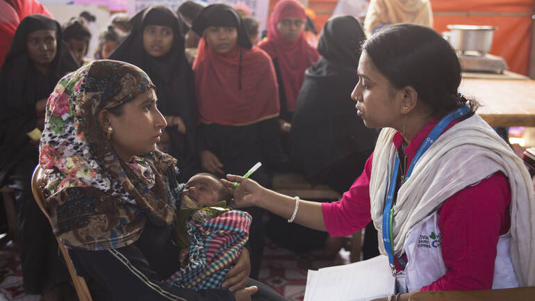 Mitarbeiterin von Aktion gegen den Hunger hilft Mutter und Kind in Bangladesch