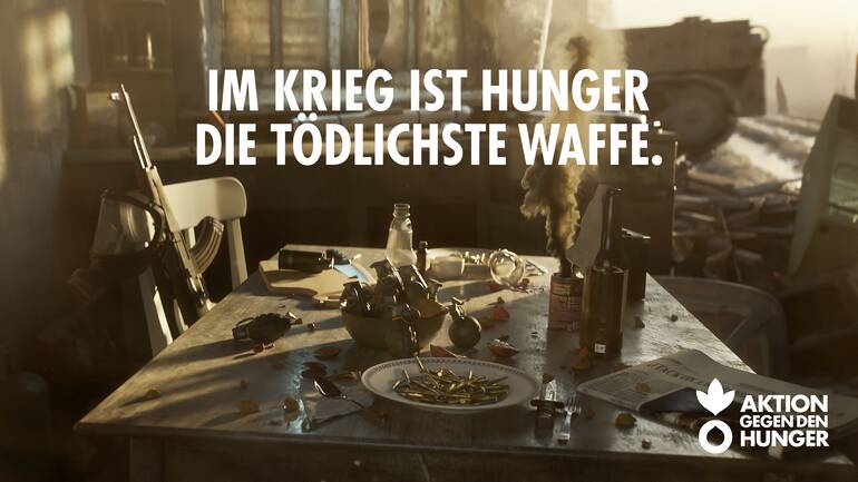 Im Krieg ist Hunger die tödlichste Waffe: Küchentisch mit Waffen, Kugeln, Granaten Im Krieg ist Hunger die tödlichste Waffe: Küchentisch mit Waffen, Kugeln, Granaten