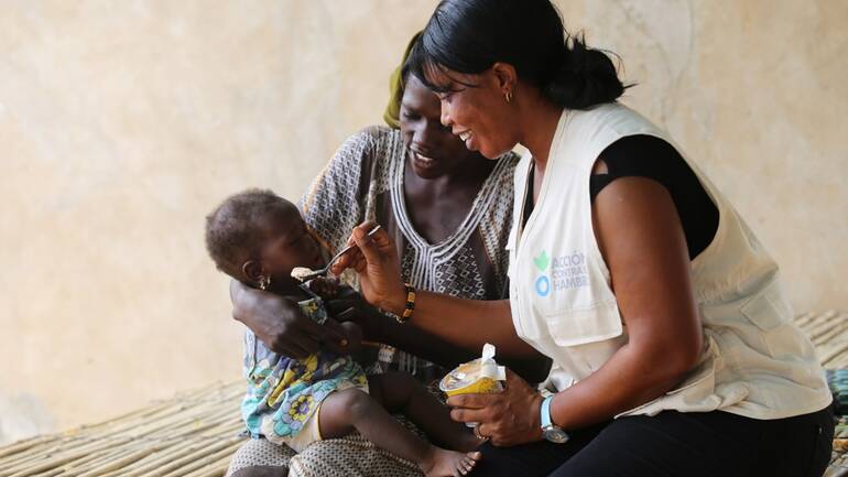 Mitarbeiterin von Aktion gegen den Hunger hilft Mutter und Kind