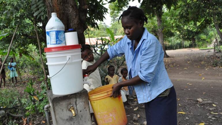 Frau nutzt lokale Wasserversorgung von Aktion gegen den Hunger