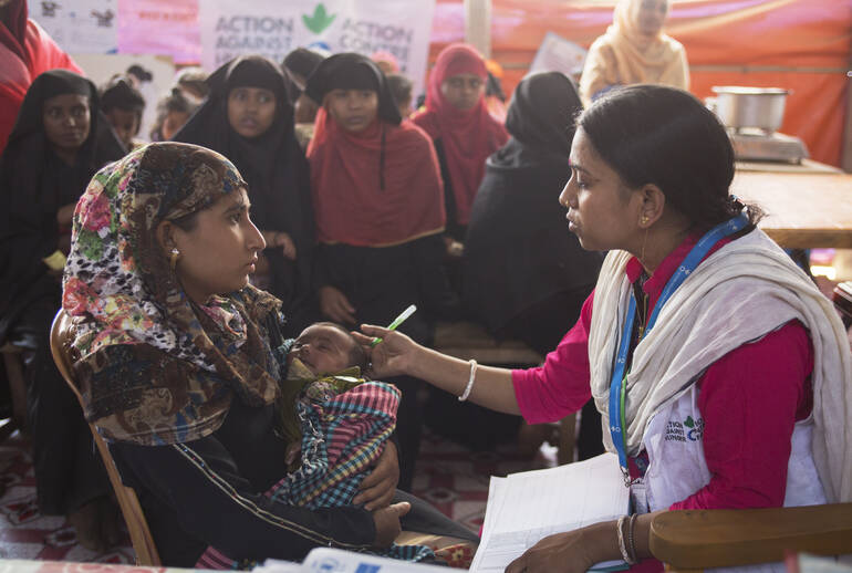 Helferin von Aktion gegen den Hunger im Gespräch mit junger Rohingya-Mutter Helferin von Aktion gegen den Hunger im Gespräch mit junger Rohingya-Mutter