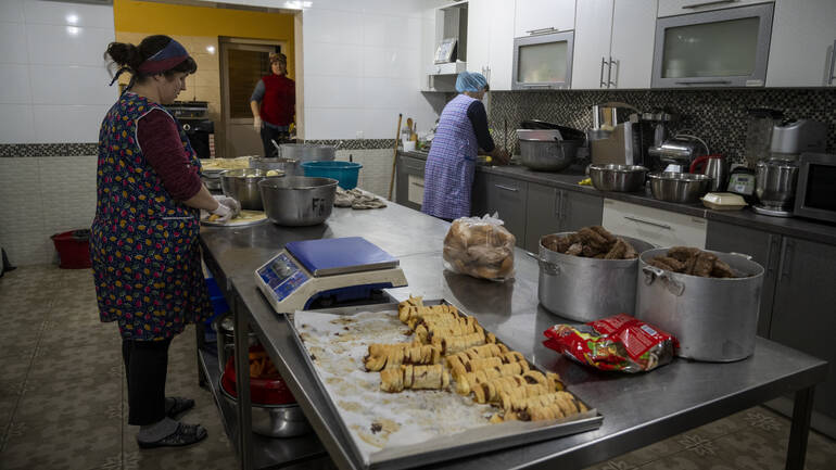 Frauen kochen in einer großen Küche frisches Essen