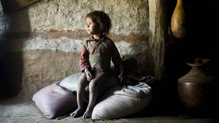 Kinder, Frauen und Männer in vielen Ländern der Welt sind auf Getreide aus der Ukraine angewiesen: Fehlt es, werden sie hungern. Ein kleines Kind sitzt in Nepal auf Säcken mit Nahrungsmitteln