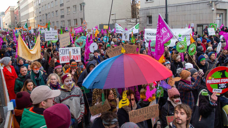 Zahlreiche bunte Menschen mit Schildern und Flaggen bei der "Wir haben es satt"-Demo