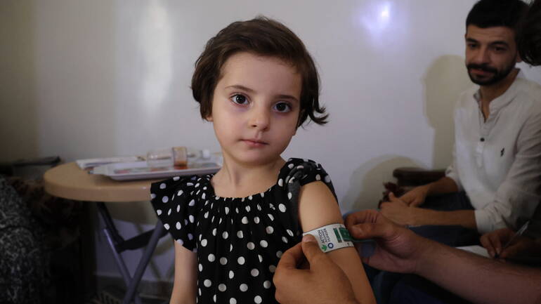Ein Mädchen aus Syrien schaut in die Kamera, während ein Mitarbeiter von Aktion gegen den Hunger seinen Armumfang mit einem MUAC-Band misst. Ein Mädchen aus Syrien schaut in die Kamera, während ein Mitarbeiter von Aktion gegen den Hunger seinen Armumfang mit einem MUAC-Band misst.