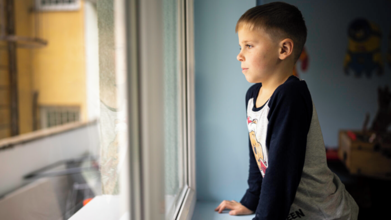 Ein aus der Ukraine geflüchteter Junge schaut vor der Musiktherapie-Stunde voller Gedanken aus dem Fenster. Ein aus der Ukraine geflüchteter Junge schaut vor der Musiktherapie-Stunde voller Gedanken aus dem Fenster.