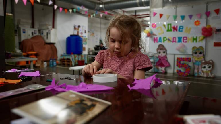 Die fünfjährige Kira aus der Ukraine bastelt konzentriert an einem Geschenk für ihre Mama. Die fünfjährige Kira aus der Ukraine bastelt konzentriert an einem Geschenk für ihre Mama.