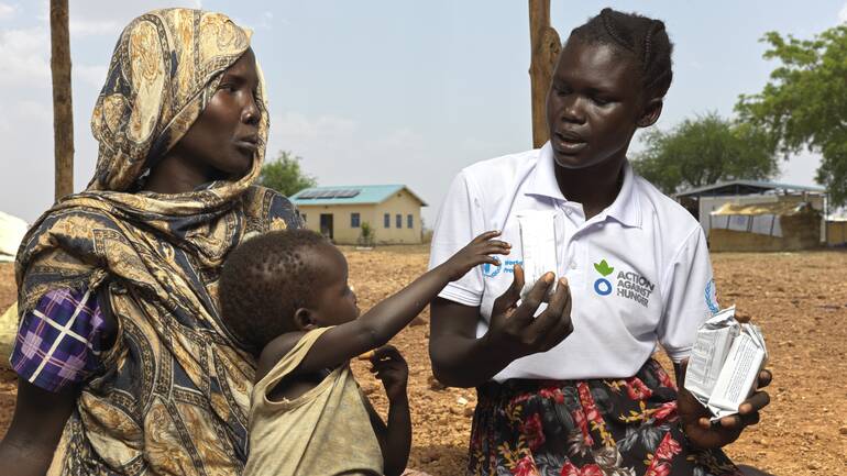 Eine Mitarbeiterin von Aktion gegen den Hunger gibt einer aus dem Sudan geflüchteten Mutter und ihrem Kind in einem Lager im Südsudan Tipps gegen Mangelernährung. Eine Mitarbeiterin von Aktion gegen den Hunger gibt einer aus dem Sudan geflüchteten Mutter und ihrem Kind in einem Lager im Südsudan Tipps gegen Mangelernährung.