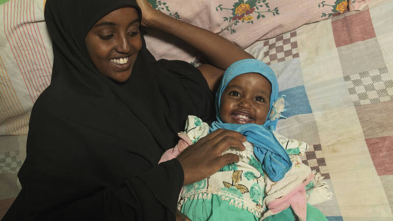 Medina und Munira liegen im Bett und kuscheln miteinander, beide sind sichtlich glücklich. Medina und Munira liegen im Bett und kuscheln miteinander, beide sind sichtlich glücklich.