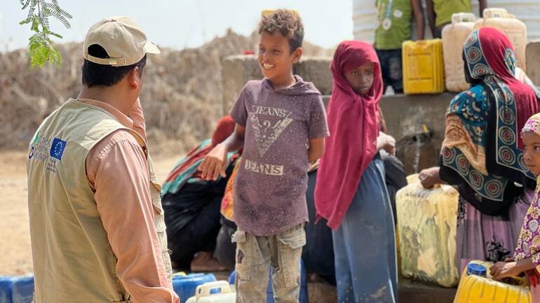 Ein Mitarbeiter von Aktion gegen den Hunger spricht mit Kindern, die gerade frisches Wasser abholen. Ein Mitarbeiter von Aktion gegen den Hunger spricht mit Kindern, die gerade frisches Wasser abholen.