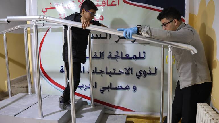 Houssam während einer Treppenübung in der Klinik zusammen mit seinem Therapeuten.
