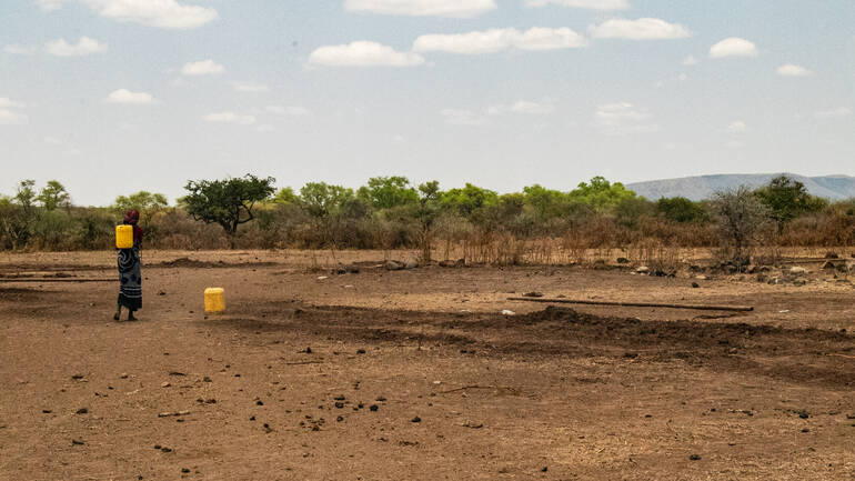 Eine Frau trägt Wasser zurück in ihr Dorf in Hobok, Borena – jeden Tag eine lebenswichtige Aufgabe.