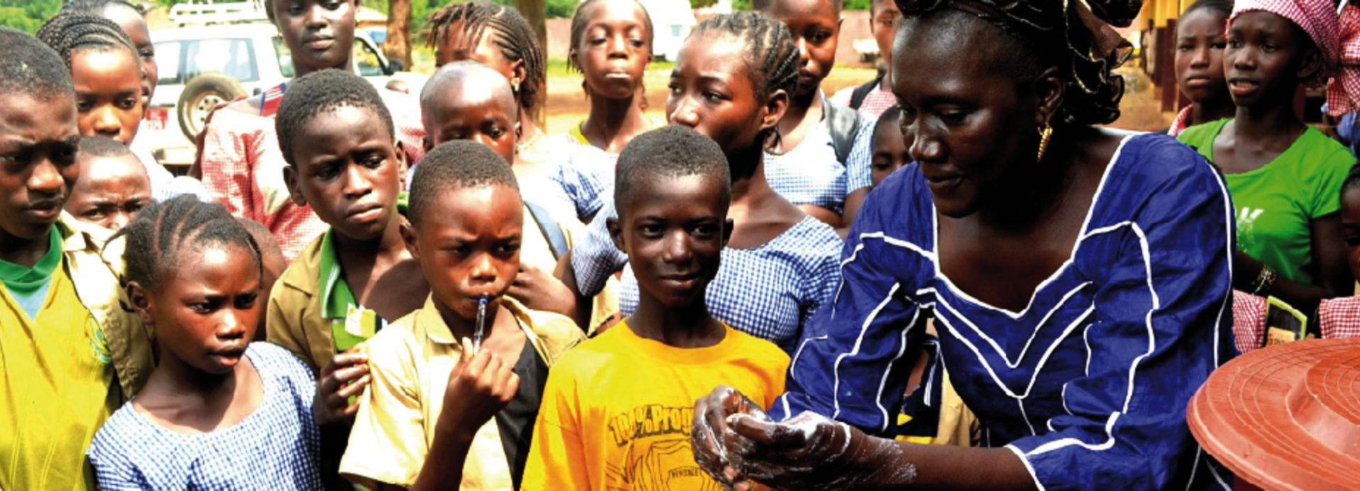 Frau erklärt in Guinea den umstehenden Menschen etwas.