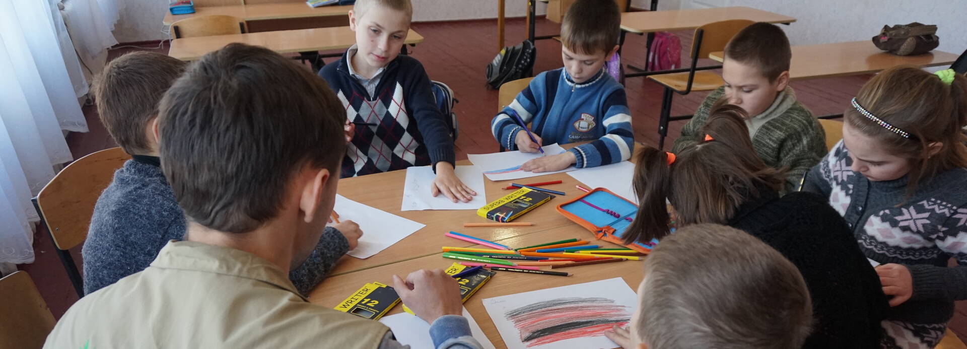 Mitarbeiter von Aktion gegen den Hunger mit Schulkindern in der Ukraine.
