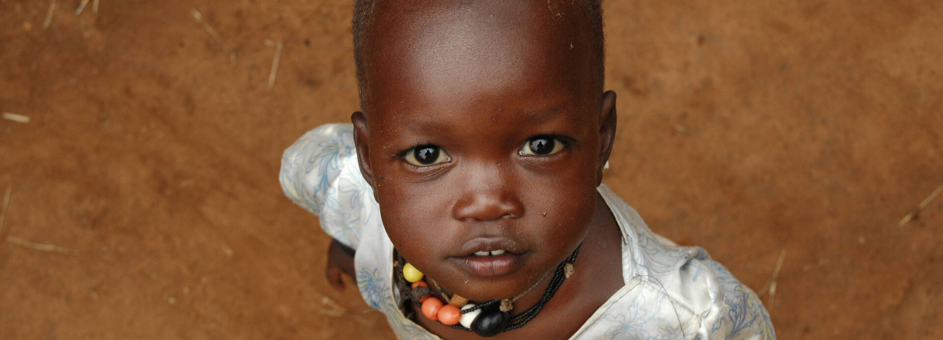 Kind in Uganda schaut nach oben.