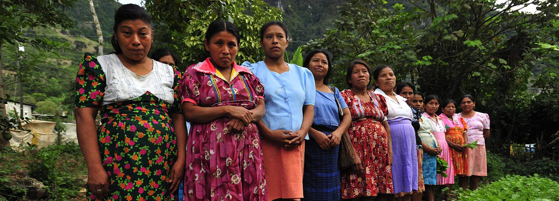 Frauen in Guatemala stehen in einer Schlange am Feld.