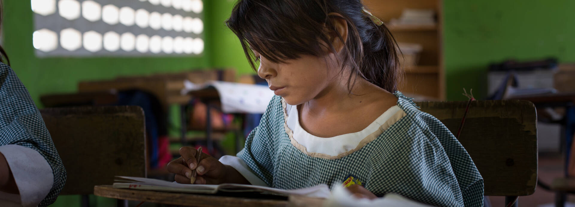 Mädchen in Kolumbien sitzt im Klassenraum.