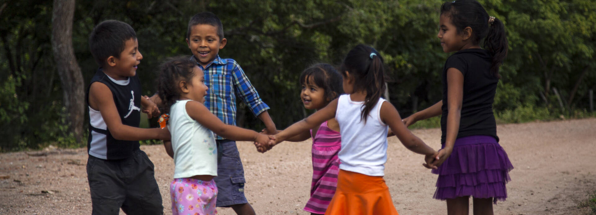 Kinder in Nicaragua tanzen im Kreis.