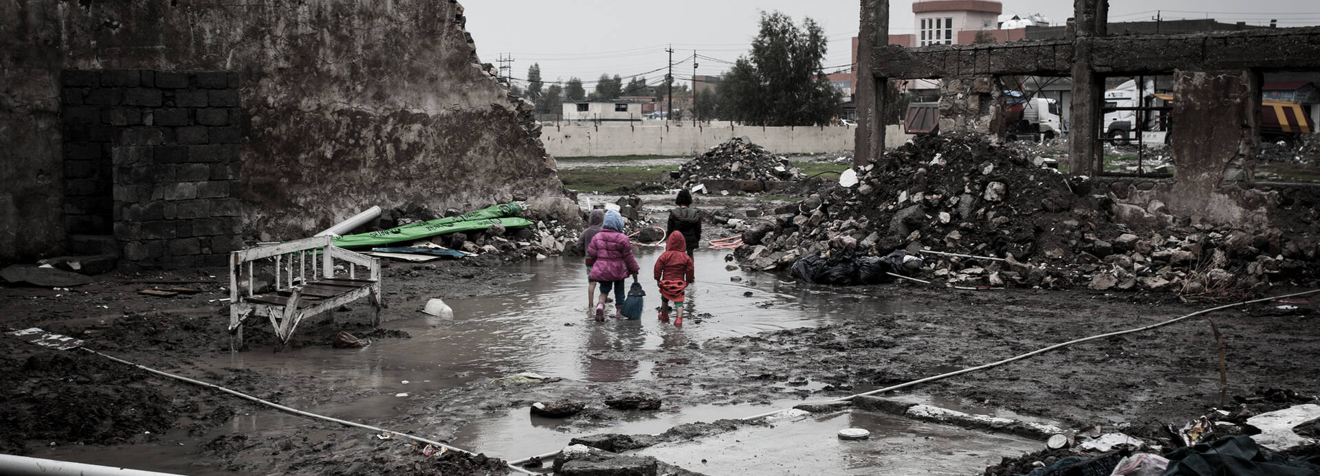 Kinder laufen durch vom Krieg zerstörte Stadt.