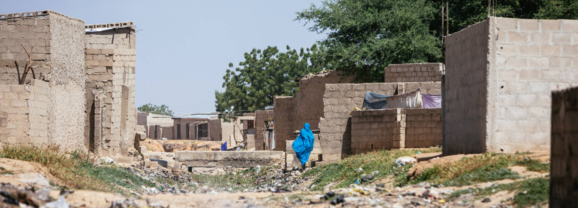 Frau läuft in Nigeria auf Schutt.