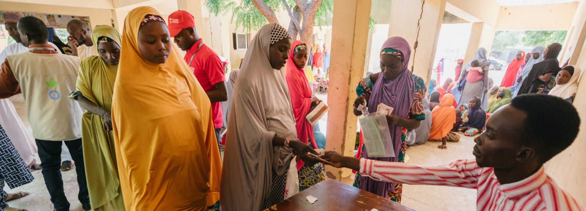 Mitarbeiter von Aktion gegen den Hunger verteilt Geld an Menschen in Nigeria.
