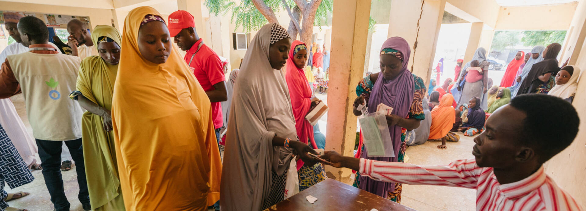 Mitarbeiter von Aktion gegen den Hunger verteilt Geld an Menschen in Nigeria. Mitarbeiter von Aktion gegen den Hunger verteilt Geld an Menschen in Nigeria.