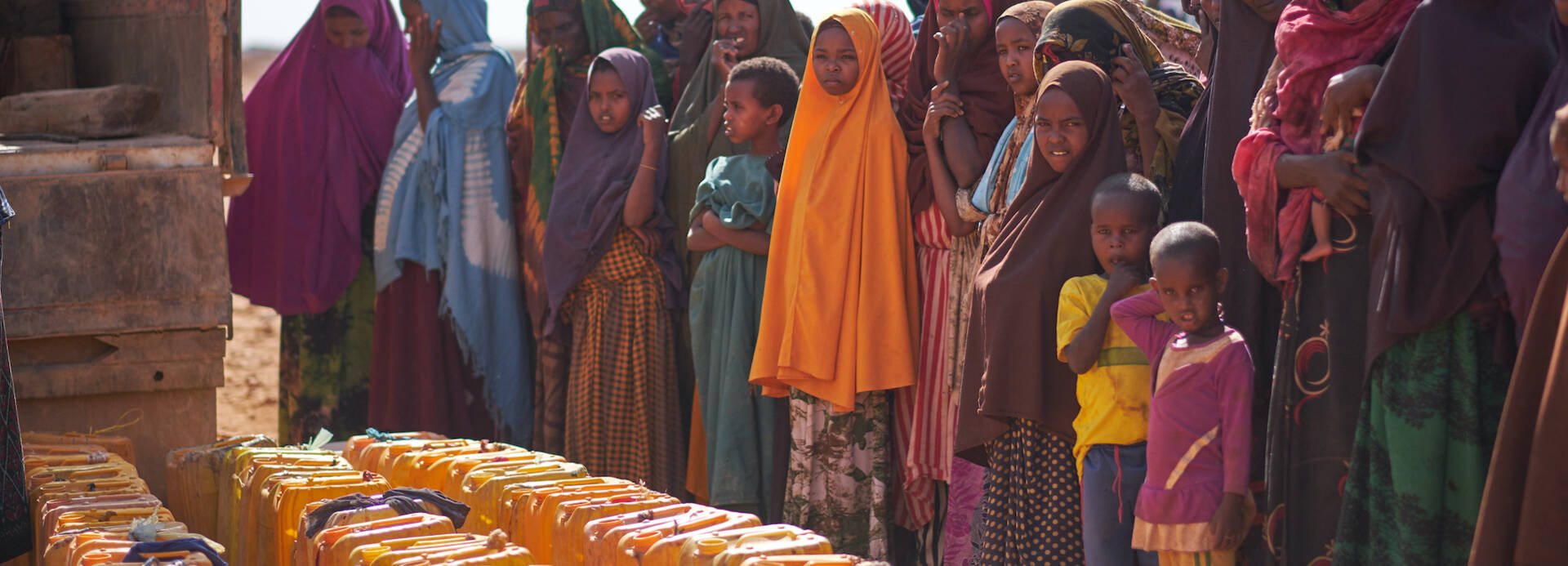 Menschen in Somalia warten mit ihren Kanistern auf sauberes Wasser aus Wassertank.