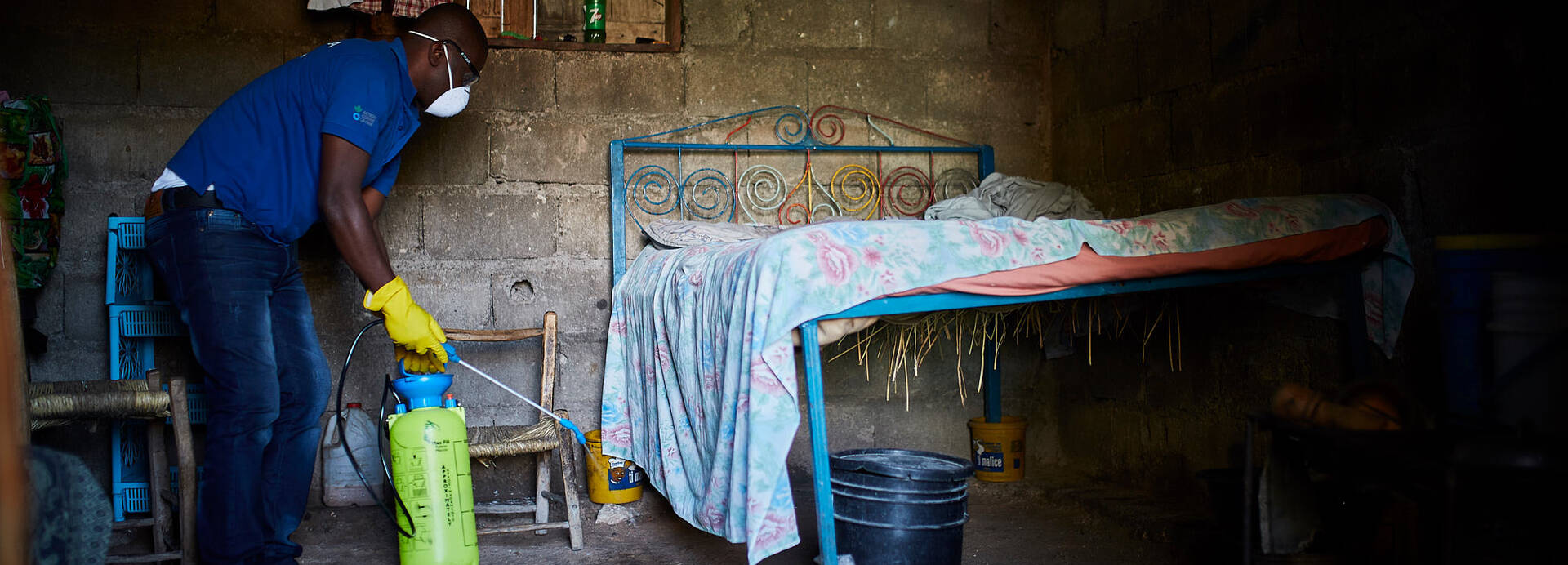 Mitarbeiter von Aktion gegen den Hunger desinfiziert Schlafzimmer.