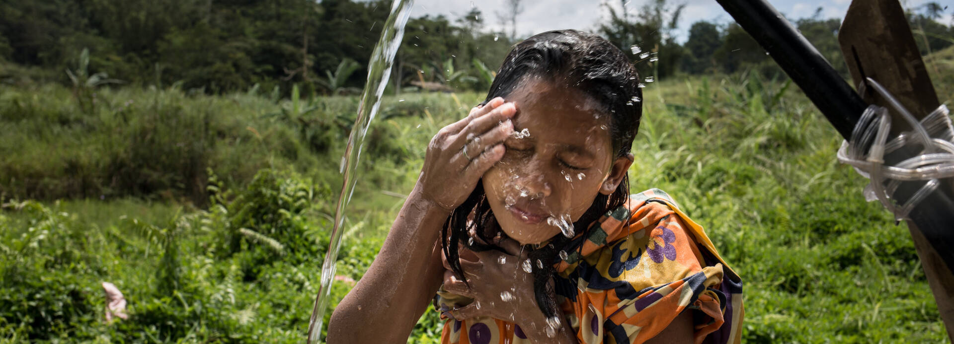 Mädchen wäscht Gesicht mit sauberem Wasser.