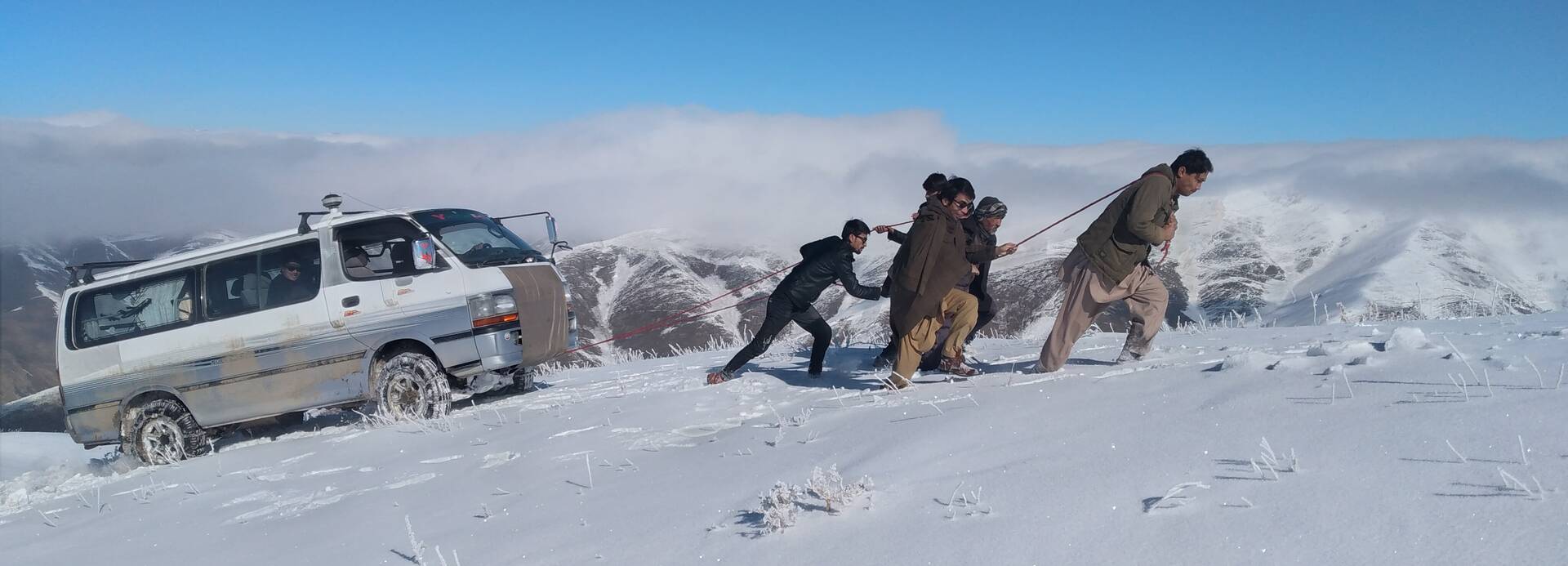afghanistan_steilhang Mitarbeitende ziehen ein Auto den steilen Hang hoch.