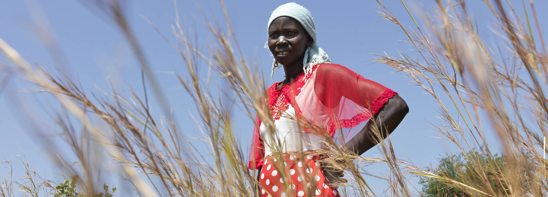 Frau steht im Feld im Südsudan