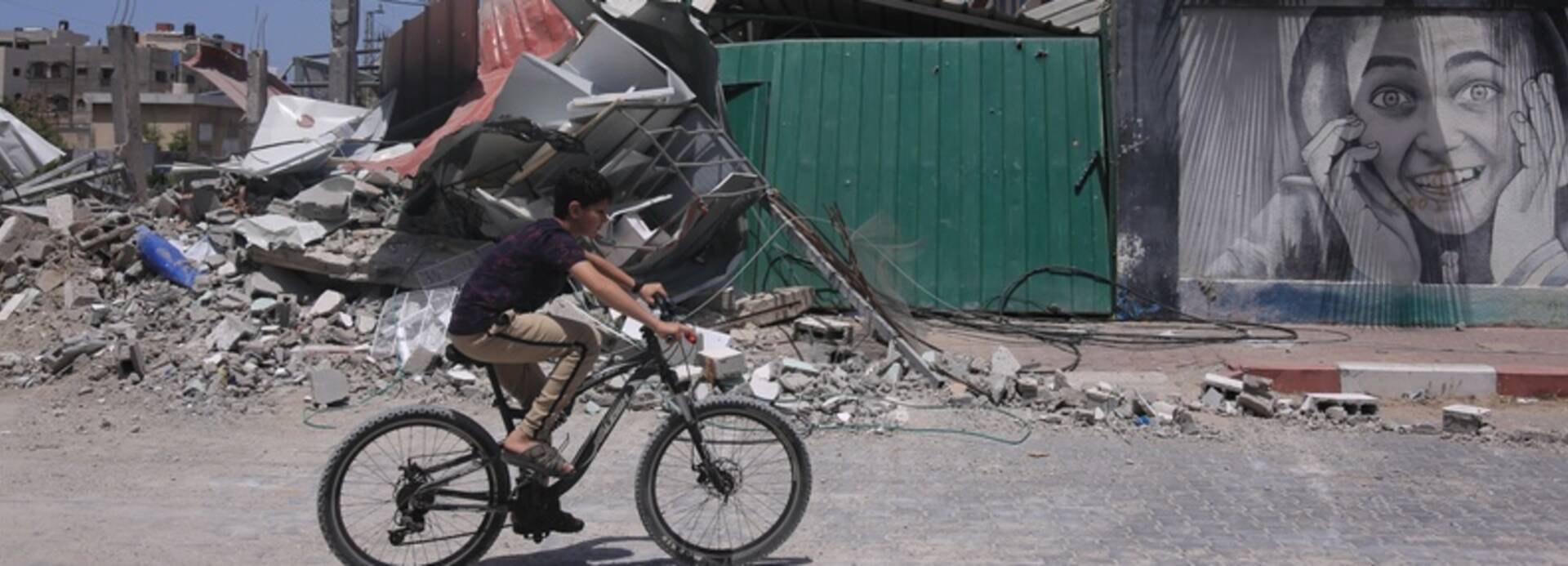 Junge fährt Fahrrad in zerstörtem Gaza