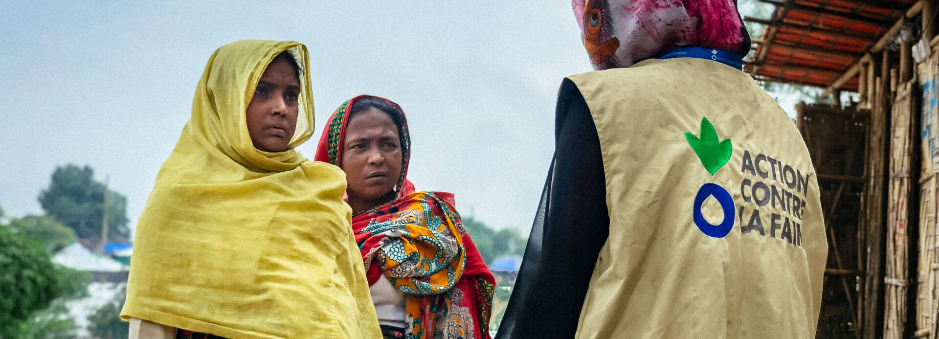 Mitarbeiterin von Aktion gegen den Hunger und zwei Frauen in Bangladesch