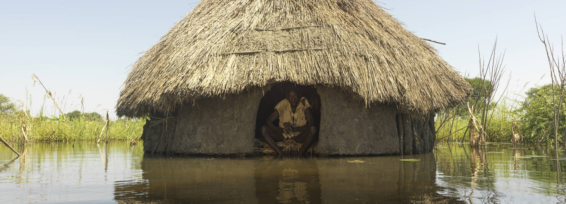 Mann im Südsudan in seinem Haus während einer Überschwemmung